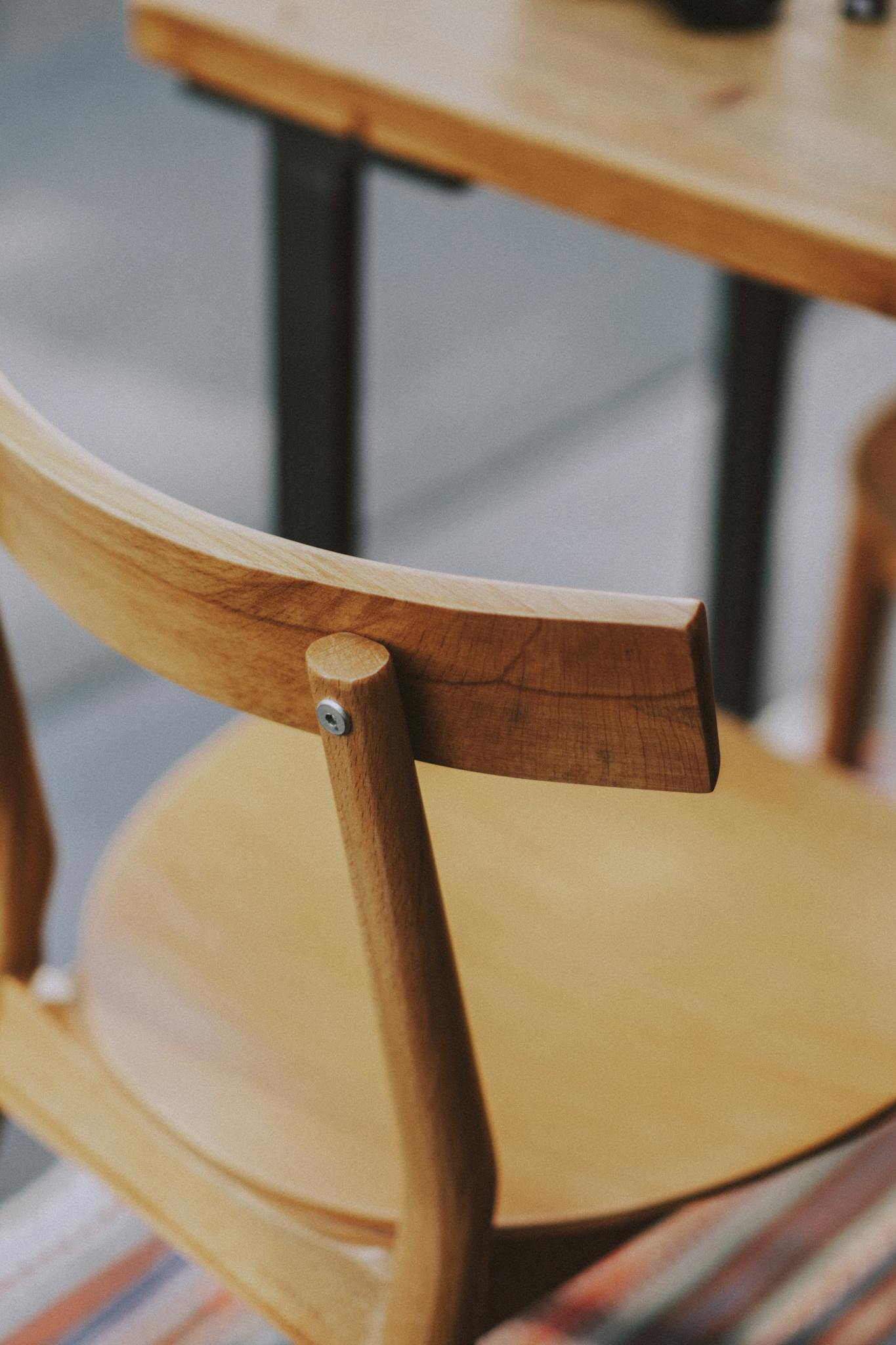 Close-up view of a wooden chair showcasing minimalist design and natural wood texture.